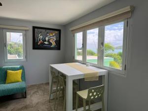 a dining room with a table and two windows at Villa Ensenada Honda in Culebra +18 photos