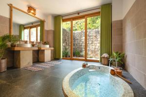 ein Bad mit einer großen Badewanne in der Mitte in der Unterkunft Green Bay Phu Quoc Resort & Spa in Phu Quoc
