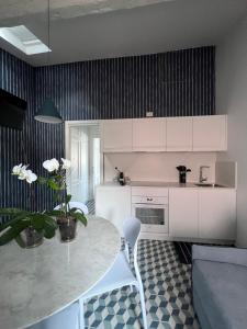 a kitchen with a table and white cabinets and a couch at About Italy Holiday Rooms and Apartments in Portovenere