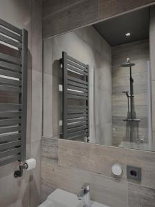 een badkamer met een wastafel en een grote spiegel bij Villa 10 min from city - perfect for families - Renovated 2024 in Garðabær