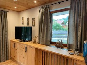 uma sala de estar com televisão e janela em Ferienwohnung Moritz em Reit im Winkl