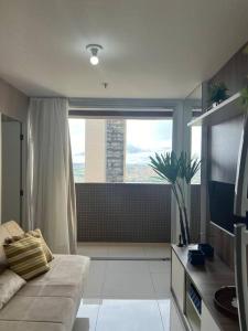 Una sala de estar con un sofá y una ventana grande. en Apartamento Dfplaza luxo, en Brasilia