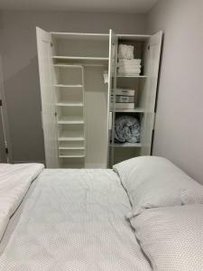a bedroom with a white bed and a closet at Luxurious brand new ground level apartment in Mississauga