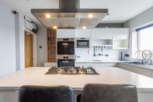 a kitchen with white cabinets and a stove top oven at SUMMER BREEZE in Horden