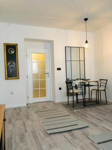 a dining room with a table and chairs and a door at Centar City Sarajevo Apartman in Sarajevo