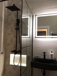 a bathroom with a black sink and a mirror at Centar City Sarajevo Apartman in Sarajevo