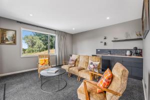 a living room with chairs and a table at Hideaway at the Bay - Taupo. in Taupo