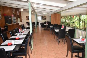 un comedor con mesas y sillas en un restaurante en Pacific Gardens Hotel, en Goroka