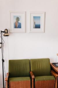 a green couch sitting next to a desk with two pictures at Botánico Casa Rural in Arcos de la Frontera