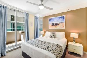 a bedroom with a bed and a large window at Redvue Holiday Apartments in Redcliffe