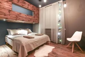 een slaapkamer met een bed en een witte stoel bij Villa 10 min from city - perfect for families - Renovated 2024 in Garðabær