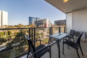a balcony with a table and chairs and a view at Central 1-Bed with Parking BBQ and Indoor Pool in Canberra