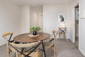 a dining room with a wooden table and chairs at Central 1-Bed with Parking BBQ and Indoor Pool in Canberra