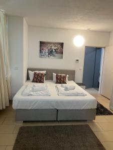 1 dormitorio con 1 cama grande con sábanas y almohadas blancas en Ferien Wohnung Stuttgart City en Stuttgart