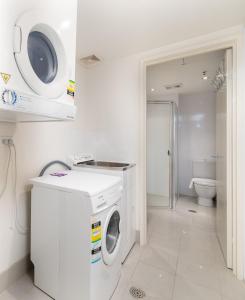 a white laundry room with a washing machine in it at Central 1-Bed with Parking BBQ and Indoor Pool in Canberra
