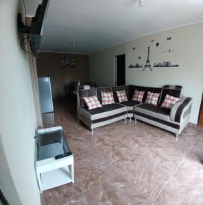 DEPARTAMENTO AMOBLADO 4 Camas 3 habitaciones في هانوكو: غرفة معيشة بها كنبتين وتلفزيون
