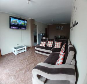 sala de estar con 2 sofás y TV en DEPARTAMENTO AMOBLADO 4 Camas 3 habitaciones, en Huánuco