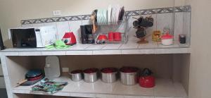 a kitchen shelf with a microwave and some utensils at DEPARTAMENTO AMOBLADO 4 Camas 3 habitaciones in Huánuco