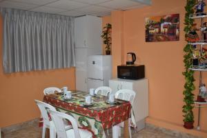 a dining room with a table and white chairs at Saga Andina II in Cusco
