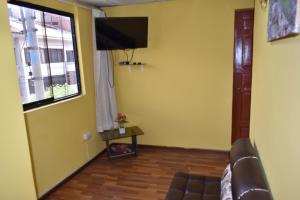 a living room with a couch and a television at Saga Andina II in Cusco