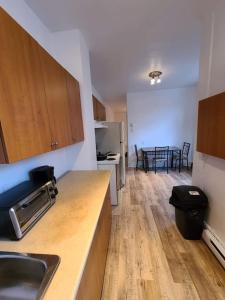 a kitchen with a sink and a table with chairs at Private Parking III Full Kitchen III Room B in Montreal