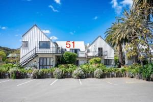 ein großes weißes Haus mit einem Nummernschild darauf in der Unterkunft Apartment 51 Akaroa in Akaroa