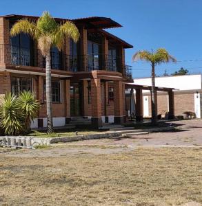 ein Gebäude mit zwei Palmen davor in der Unterkunft Finca G in Pachuca de Soto