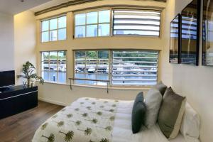 a large room with a bed and large windows at Harbour View Woolloomooloo in Sydney