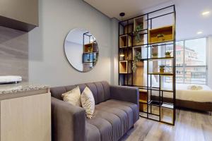uma sala de estar com um sofá e um quarto em Bohemio Luxury Loft Zona T em Bogotá