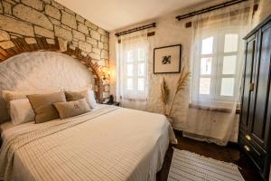 a bedroom with a large bed and two windows at Aleysim Alaçatı-Design Als in Alacati