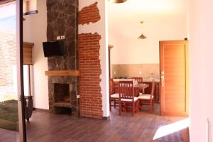 a living room with a brick fireplace and a dining room at La Cuadra Cabaña 2 in Zacatlán