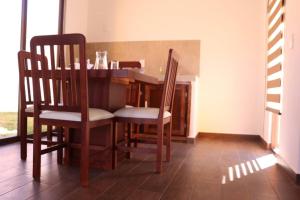 a dining room with a wooden table and chairs at La Cuadra Cabaña 2 in Zacatlán