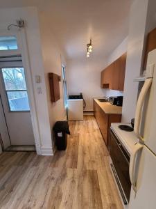 uma cozinha com pisos em madeira e um forno com placa de fogão em Private Parking III Full Kitchen III Room B em Montreal