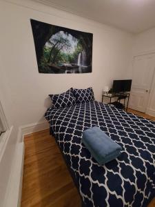ein Schlafzimmer mit einem Bett und einem Wandgemälde in der Unterkunft Private Parking III Full Kitchen III Room B in Montreal