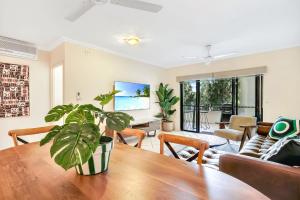 uma sala de estar com uma mesa de jantar com uma planta em Central Park em Cairns North