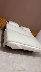 1 cama con sábanas blancas y almohadas en una habitación en Atlantis en Nuakchot