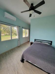 una camera con letto e ventilatore a soffitto di Tranquil Waterfront Escape a Orange Walk Town