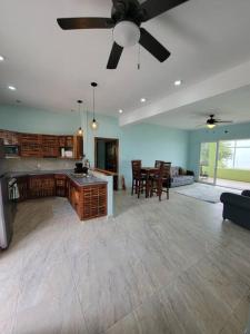a large kitchen and living room with a ceiling fan at Tranquil Waterfront Escape in Orange Walk
