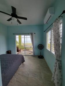 a bedroom with a bed and a ceiling fan at Tranquil Waterfront Escape in Orange Walk