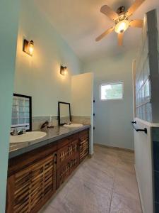 a bathroom with a sink and a ceiling fan at Tranquil Waterfront Escape in Orange Walk