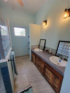 a bathroom with two sinks and a mirror at Tranquil Waterfront Escape in Orange Walk
