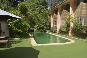 a swimming pool in a yard next to a house at Pacific Gardens Hotel in Goroka