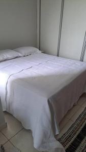a white bed with a white blanket on it at Apartamento na Ponta Negra, 2 quartos, sendo uma suite in Manaus