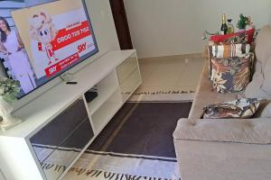 a living room with a flat screen tv on a table at Apartamento na Ponta Negra, 2 quartos, sendo uma suite in Manaus