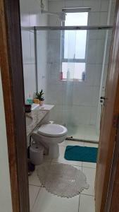 a small bathroom with a toilet and a shower at Apartamento na Ponta Negra, 2 quartos, sendo uma suite in Manaus