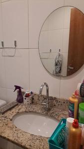 a bathroom counter with a sink and a mirror at Apartamento na Ponta Negra, 2 quartos, sendo uma suite in Manaus