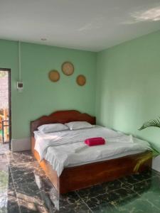 een slaapkamer met een groot bed met groene muren bij La plage by lee & hap guest house in Kampot