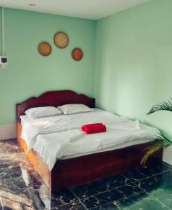 La plage by lee & hap guest house في كامبوت: غرفة نوم مع سرير وفوط حمراء عليه