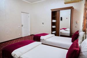 um quarto de hotel com duas camas e um espelho em ART Hotel em Tashkent