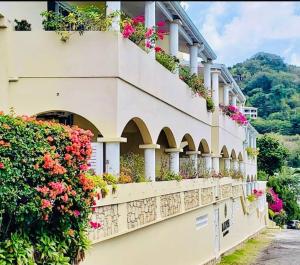 a building with flowers on the side of it at Oceans Beach Condo in Morne Rouge